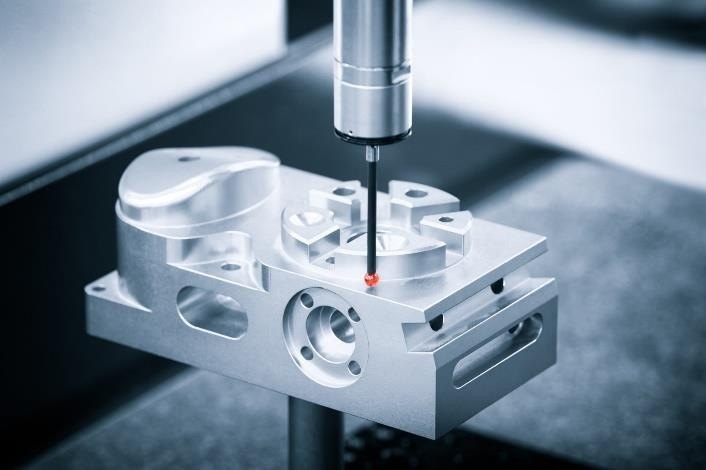 Coordinate measuring machine probing a machined aluminium manifold
